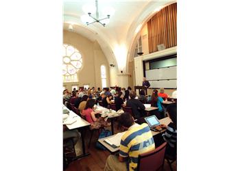 lecture in session in a hall with stained glass
