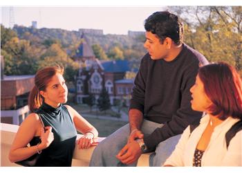 students chatting with a campus building backdrop