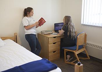 students chatting outside campus housing