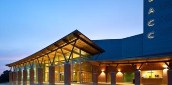 modern building with 'eacc' on facade, lit up at twilight