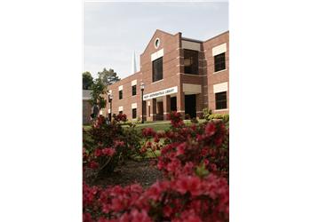college campus building with a lawn and flowers in the foreground