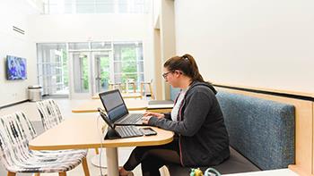 student studying with laptop in lobby