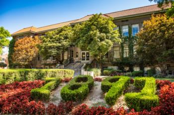 lush campus grounds with well-maintained greenery and a historic building
