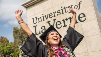 graduate celebrating in front of the university of la verne sign