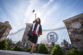 graduate throws cap in front of sacred heart university gate