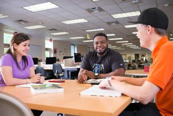 three students studying at a table