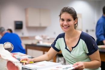 smiling female student studying anatomy