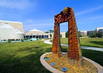 sculpture with two tall elements near a building