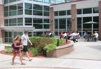 students walk by a modern building with glass windows at east georgia state college