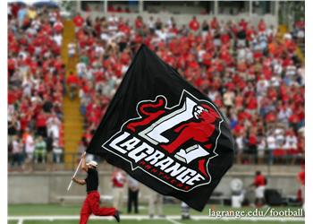 person with 'LaGrange College' flag at a crowded stadium