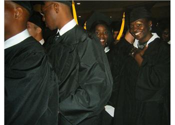 students in graduation gowns smiling