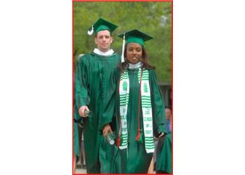 graduates in green gowns at ceremony
