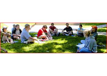 students seated in a circle on grass