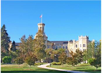 historic building with tower and green trees under blue sky