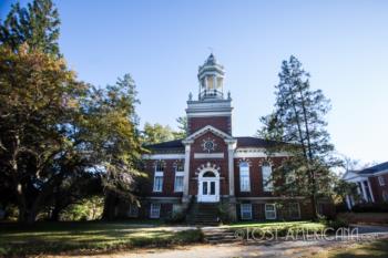 brick building with a clock tower amidst trees