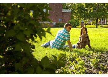 two people sitting on grass in campus
