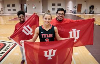 students holding IU flags in a gym