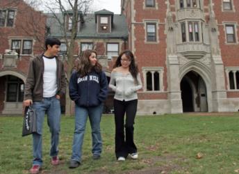 students walking on grassy area near brick building