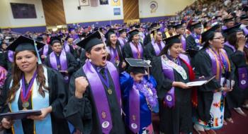 graduates in caps and gowns celebrate at a university ceremony