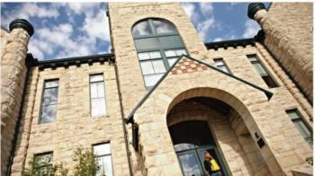 angled view of a historic stone building with arched entry