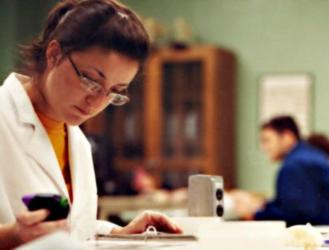 student studying with smartphone and notebook