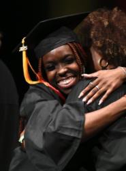 graduate hugging a mentor at a graduation ceremony