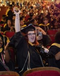graduates celebrate during a ceremony with cap and gowns
