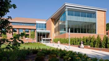 modern brick and glass building with large windows and a pathway in front