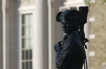 silhouette of a statue with buildings in the background