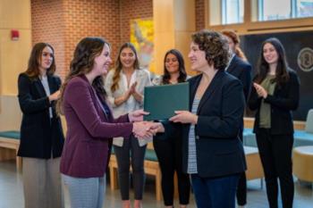 two women shaking hands, receiving certificate