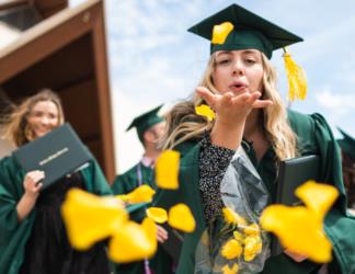 graduates tossing yellow caps in the air
