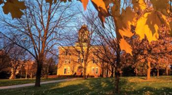 sunset view of campus building with autumn trees