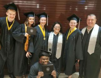 group of graduates smiling with diplomas