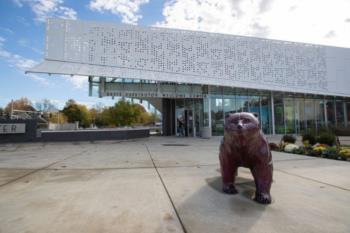 statue of a bear in front of a building with decorative facade