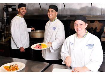 three chefs presenting dishes in kitchen