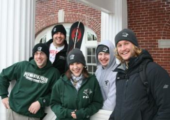 group of smiling people in winter attire with 'penn state' logos