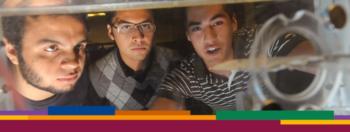 three students looking at scientific equipment