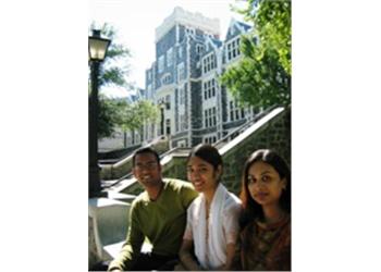 three students smiling in front of a campus building