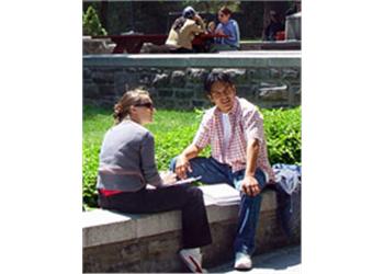 two people conversing on a campus bench