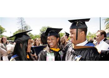 group of graduates smiling at a commencement ceremony