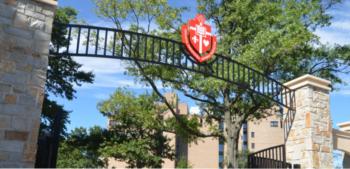 arched gate with a crest at a college entrance