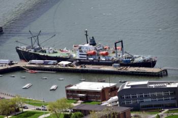 ship docked near campus buildings