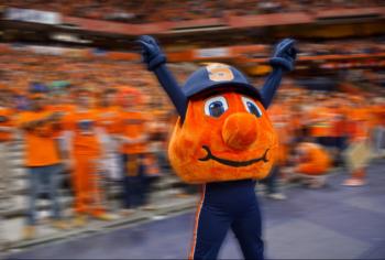 mascot in front of cheering sports crowd