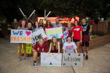 students holding welcome signs at orientation