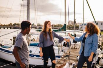 students chatting on a sailboat dock