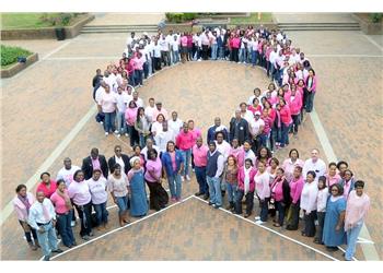 group forms heart shape for breast cancer awareness