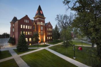 historic brick building with tower and trees on campus