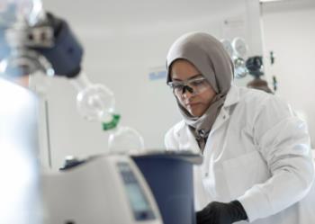 scientist in lab wearing safety goggles and hijab