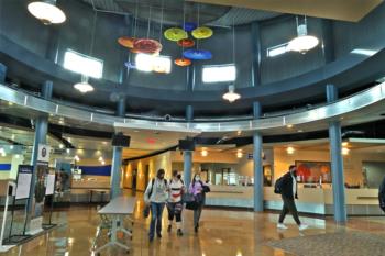 interior view of clark state college with students walking and colorful hanging lights