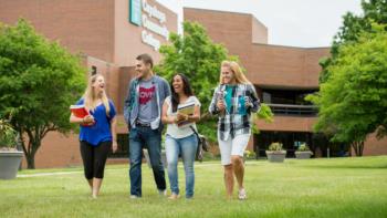 students walking on grass outside cuyahoga community college building